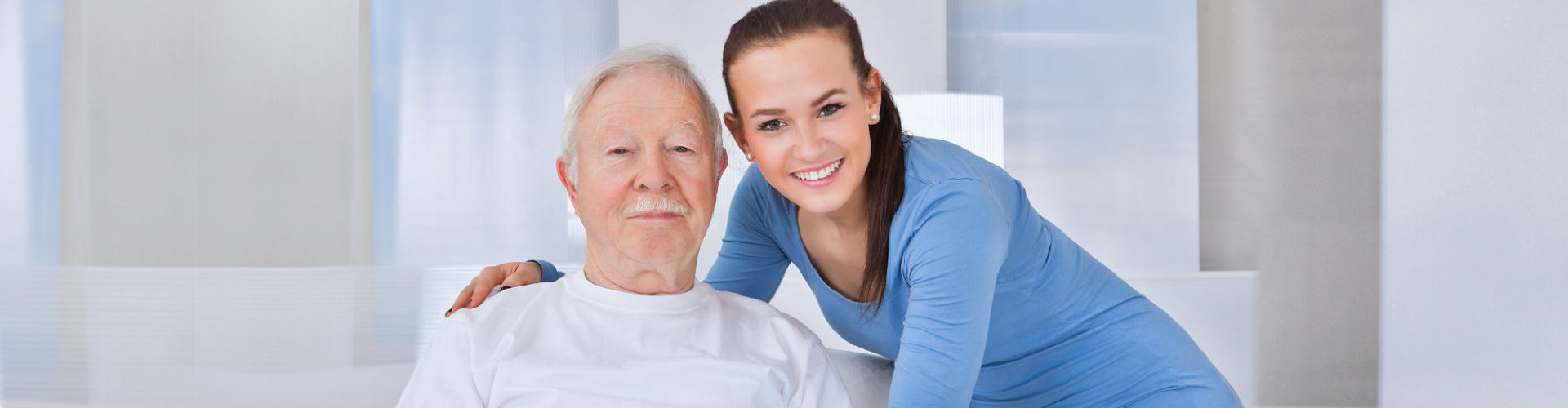 female caregiver holding the elderly in his shoulders