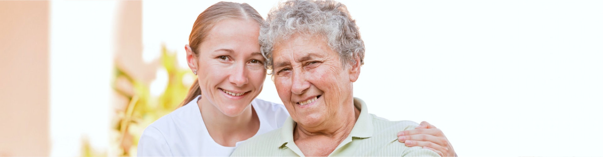 female aide with the elderly woman posing to the camera